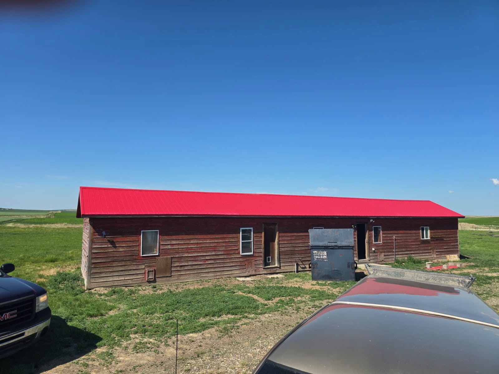 Renovated barn with a finished red metal roof in the Alberta countryside