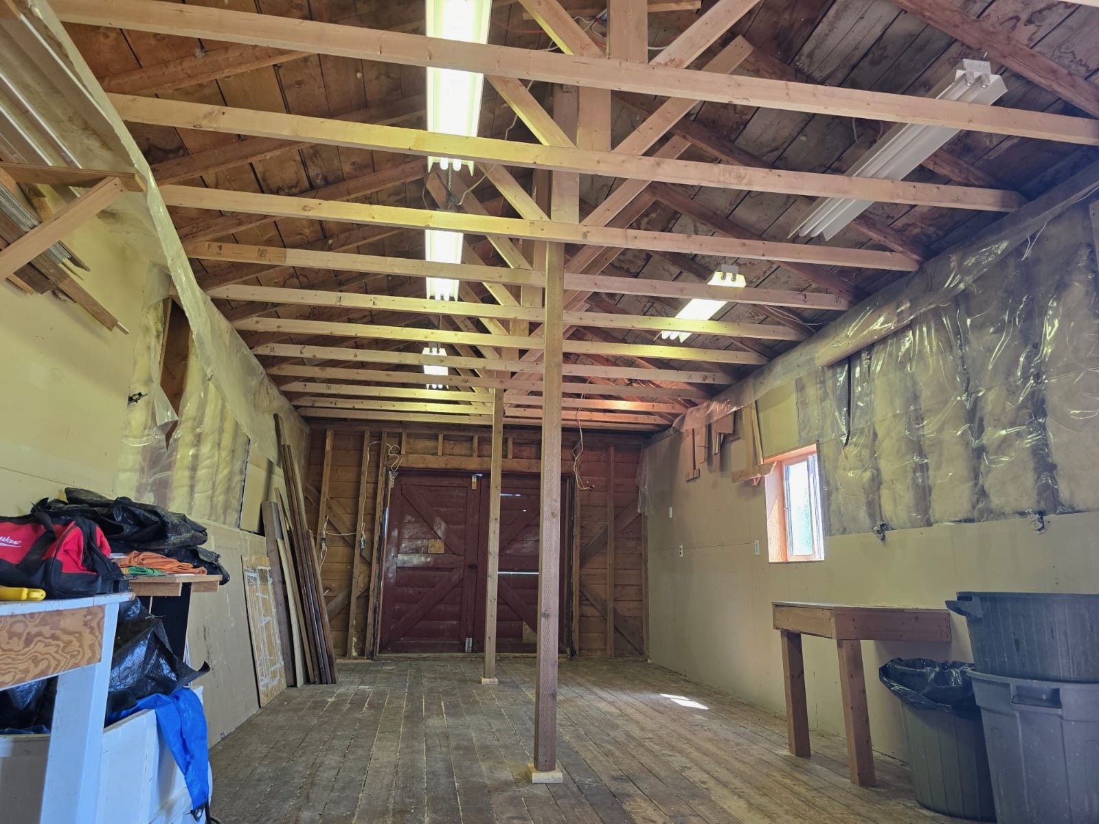 Interior of the same barn showing exposed wood roof trusses