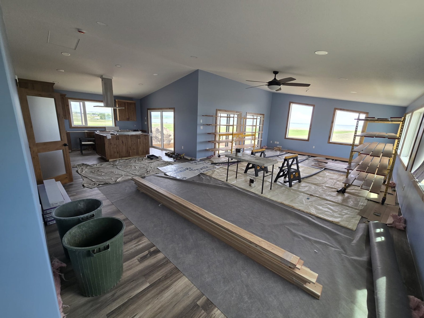 Blue walls, large windows, wood trim and flooring during interior finishing